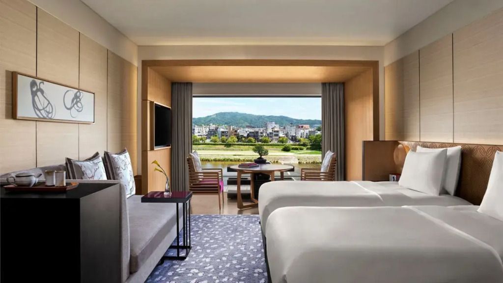 Luxuriöses Zimmer mit Doppelbett und Panoramablick auf den Fluss und die Stadt.