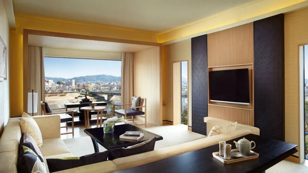 Lichtdurchflutetes Zimmer mit Sitzbereich und Blick auf Fluss und Stadt