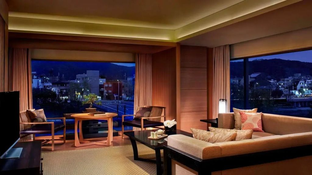 Geräumiger Wohnbereich der Suite mit eleganten Möbeln und Stadtblick.