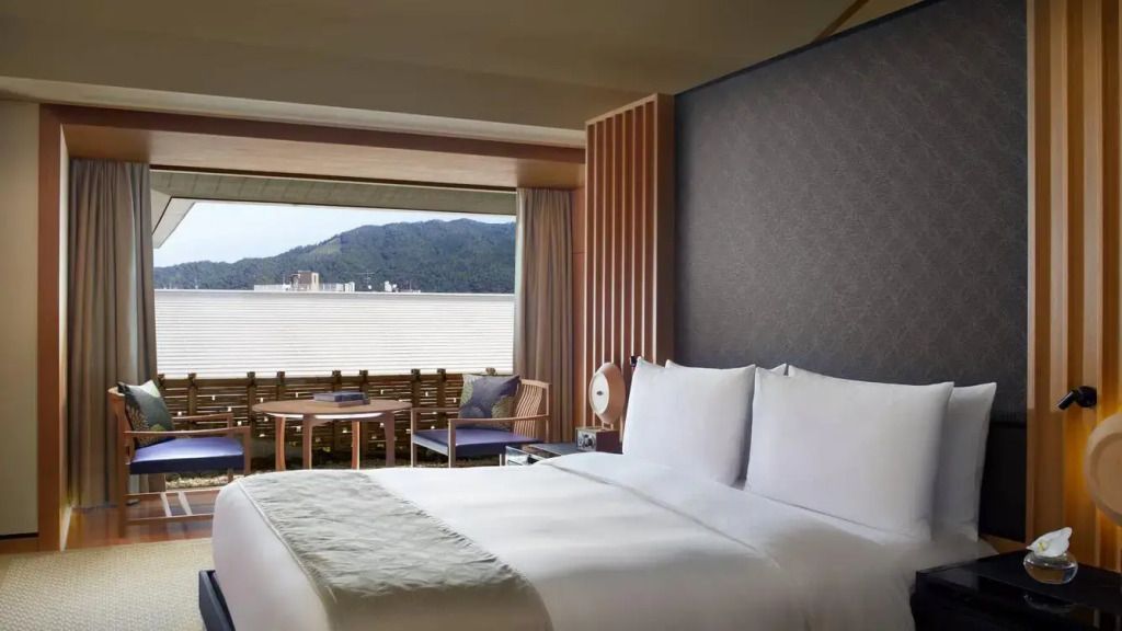 Luxuriöse Suite mit Doppelbett und Bergblick durch ein großes Panoramafenster