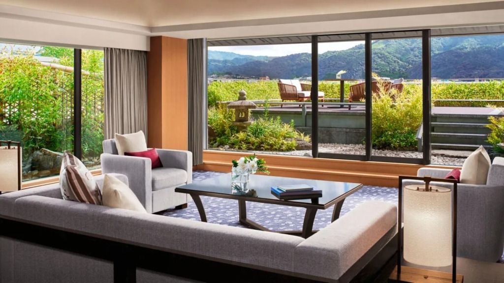 Gemütliches Wohnzimmer mit Aussicht auf grüne Terrasse und Berge