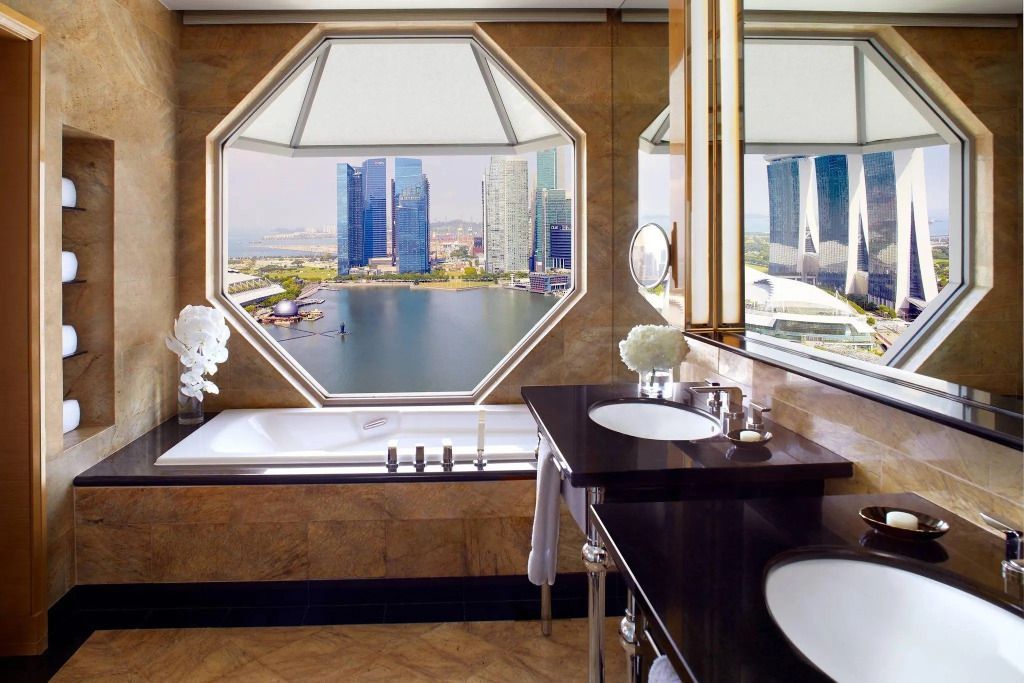 Exquisites Badezimmer mit Blick auf Marina Bay durch großes Fenster.