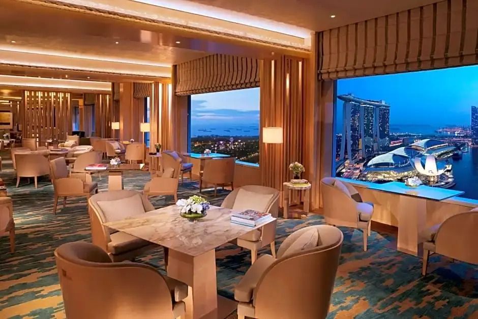 Lounge mit Panoramablick auf Marina Bay Sands bei Abenddämmerung.