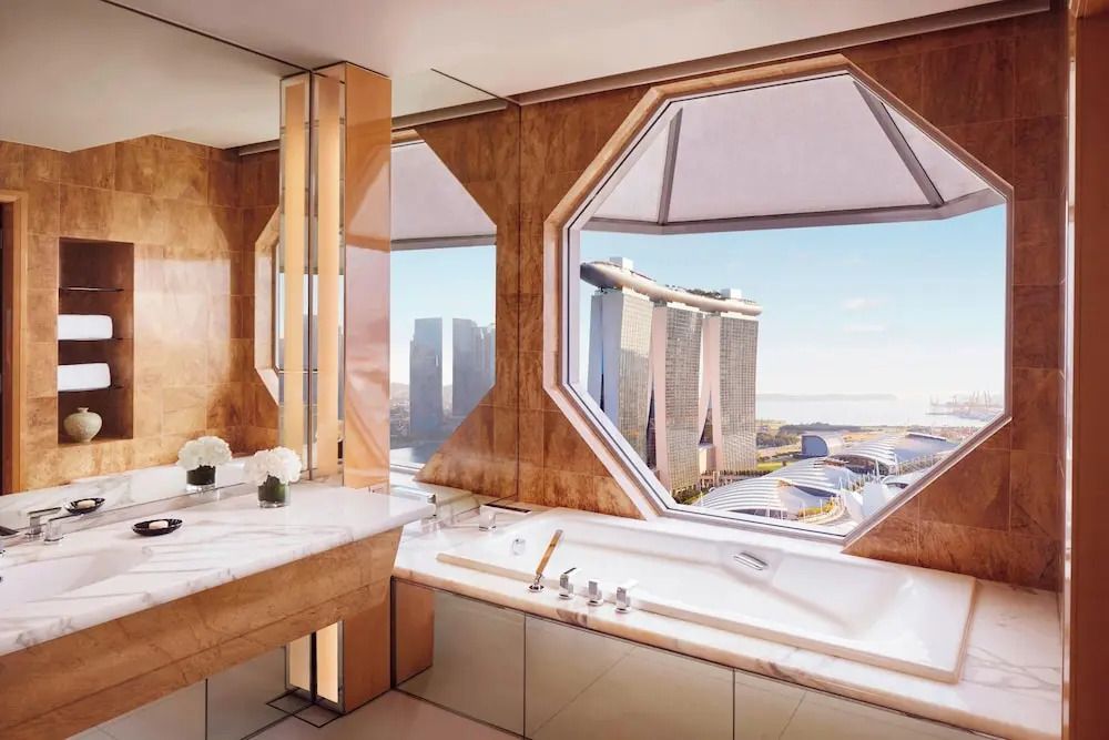 Badezimmer mit freistehender Wanne und Blick auf Marina Bay.