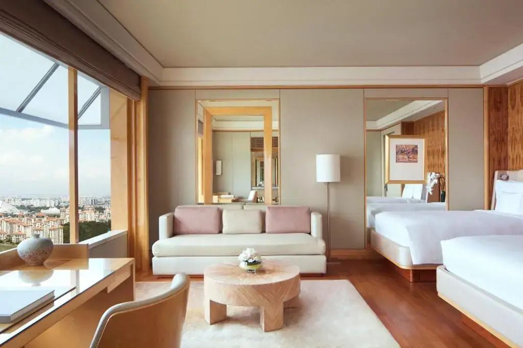 Helles Doppelzimmer mit eleganter Möblierung und großen Fenstern mit Ausblick.