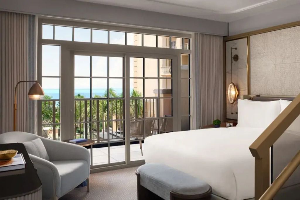 Helles Schlafzimmer mit Doppelbett und Balkonblick auf das Meer