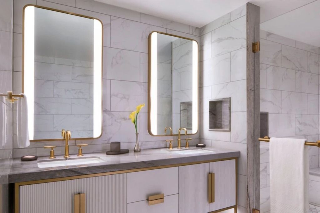 Elegantes Badezimmer mit Marmorwänden und beleuchteten Spiegeln