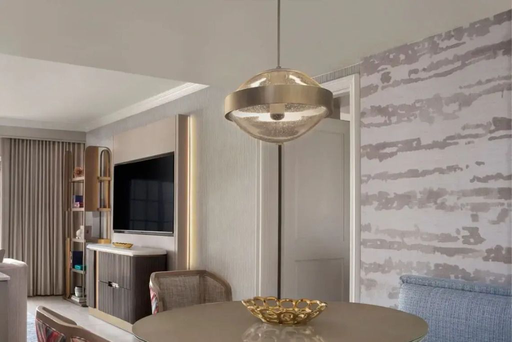 Designerlampe über einem runden Tisch in der Suite mit stilvoller Dekoration
