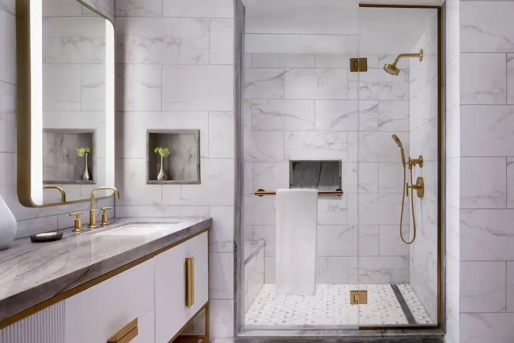 Luxuriöses Badezimmer mit großzügiger Dusche und goldenen Akzenten