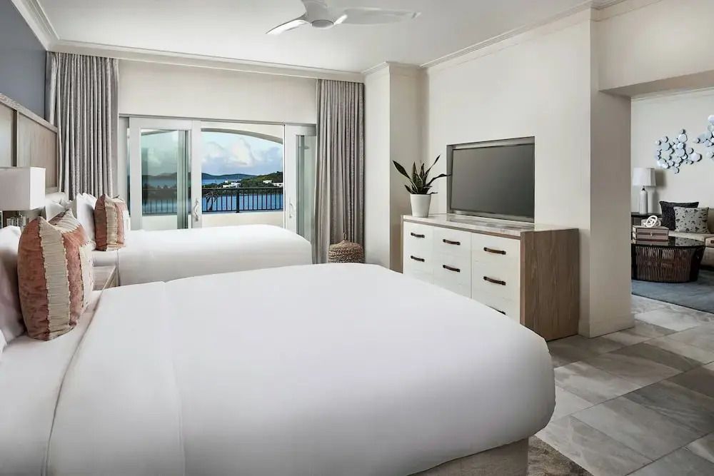 Helles Schlafzimmer mit zwei Betten und Blick auf das Meer