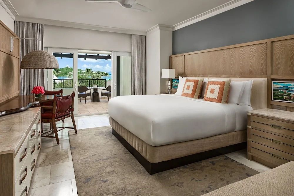 Geräumiges Schlafzimmer mit großem Bett und Zugang zum Balkon mit Meerblick