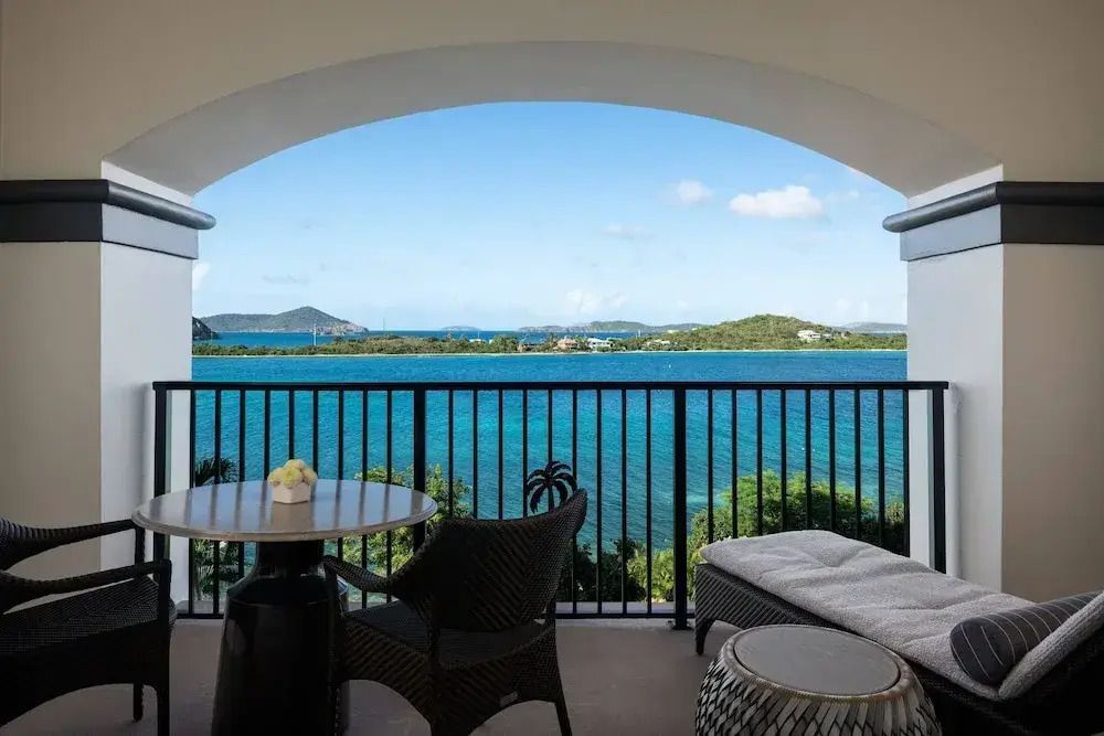 Balkon mit Sitzgelegenheit und beeindruckendem Blick auf das türkisblaue Meer