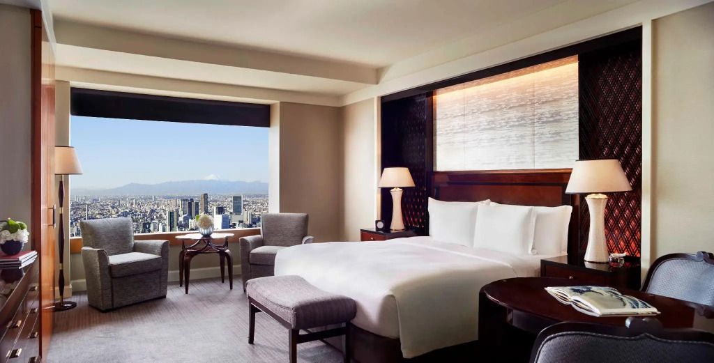 Modernes Zimmer mit Doppelbett und beeindruckender Aussicht auf die Skyline von Tokyo.