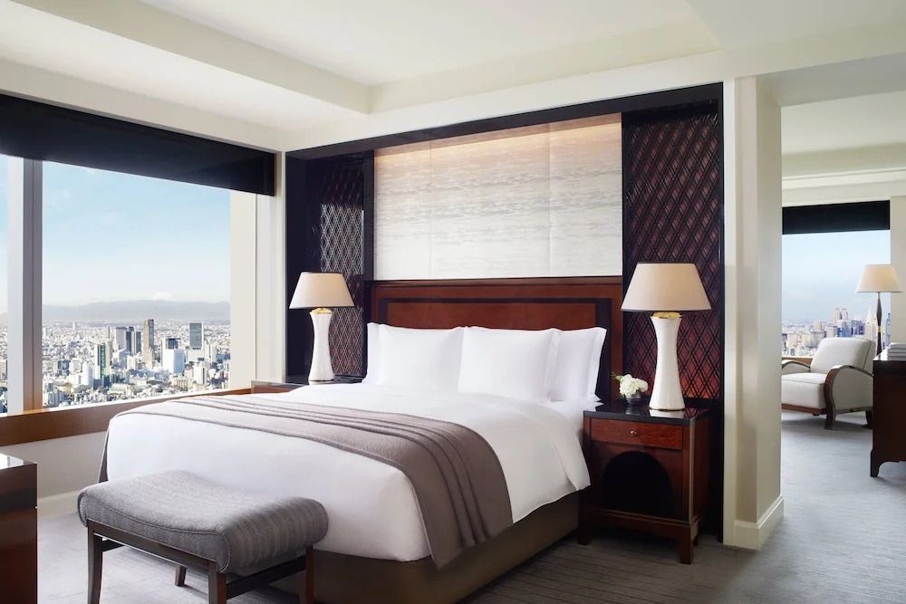 Großes Doppelbett mit Stadtblick im Tageslicht in der Executive Suite.