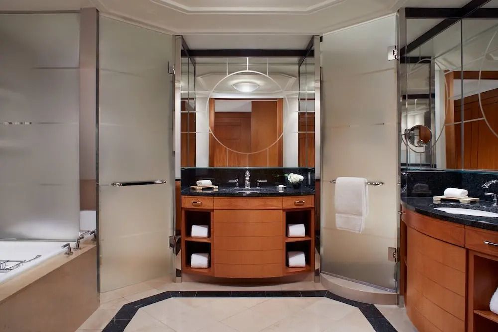 Luxuriöses Badezimmer mit großen Spiegeln und edlem Waschbecken.