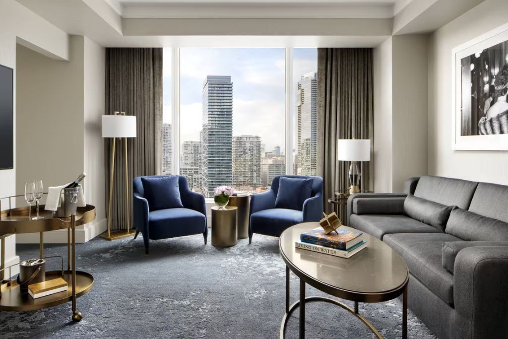 Elegantes Wohnzimmer mit blauen Sesseln und Panoramafenster mit Blick auf die Stadt