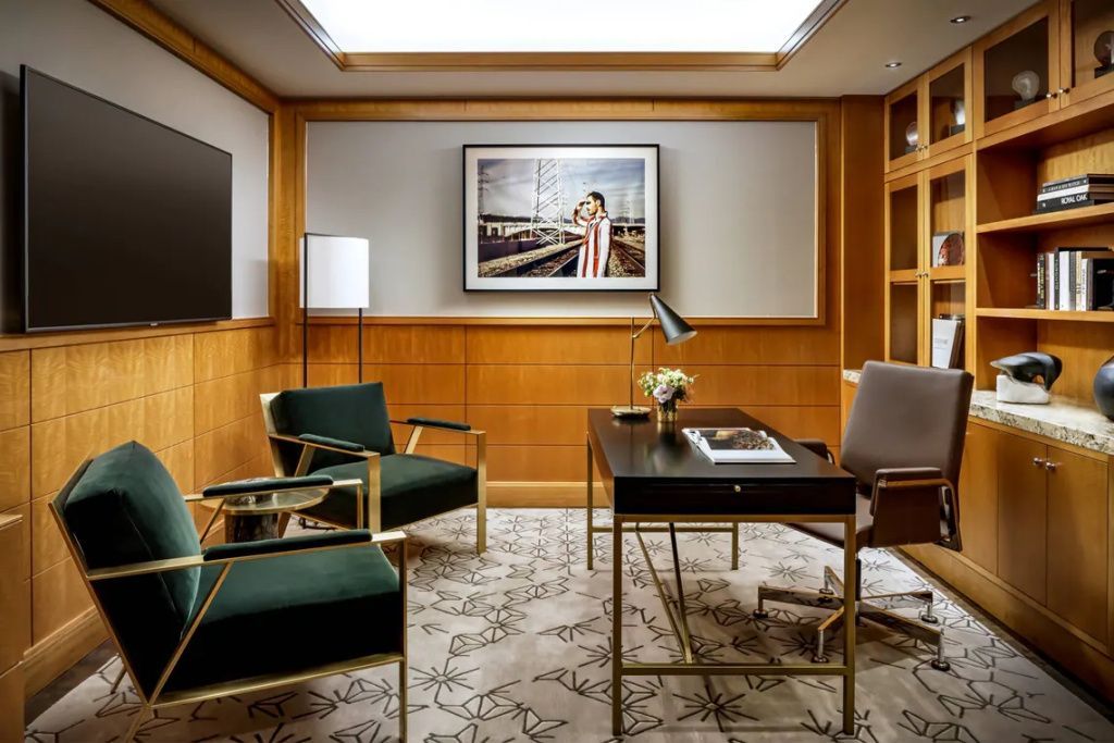 Stilvolles Arbeitszimmer mit Schreibtisch, weißen Wänden und Kunstwerk an der Wand.