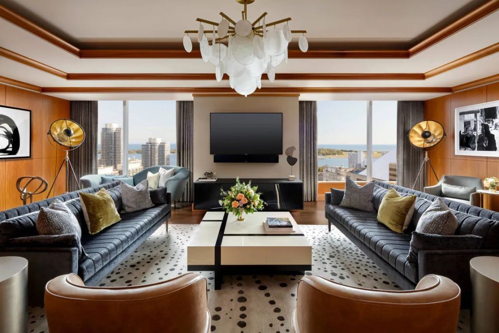 Geräumiges Wohnzimmer mit zwei Sofas, großem Fernseher und Stadtblick.