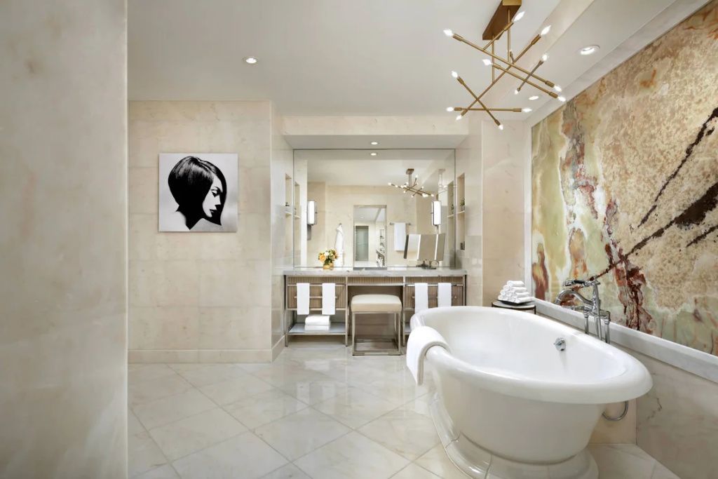 Elegantes Badezimmer mit freistehender Badewanne und großer Kunst an der Wand.