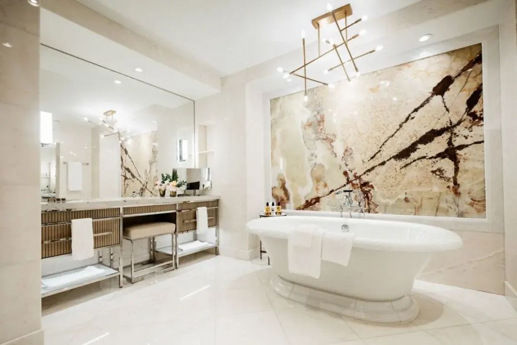 Helles Badezimmer mit Badewanne, Sitzgelegenheit und luxuriösem Interieur.