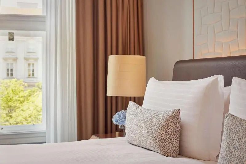 Naheaufnahme des Bettbereichs im Deluxe Doppelzimmer mit dekorativem Kissen
