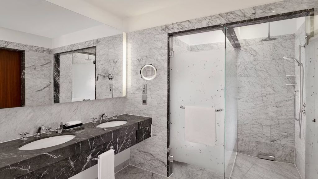 Modernes Badezimmer mit gläserner Dusche in elegantem Marmor