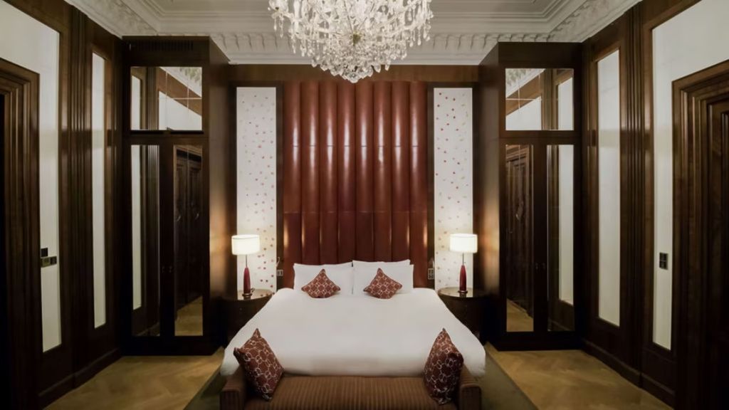 Luxuriöses Schlafzimmer mit Kronleuchter und eleganten Holzelementen