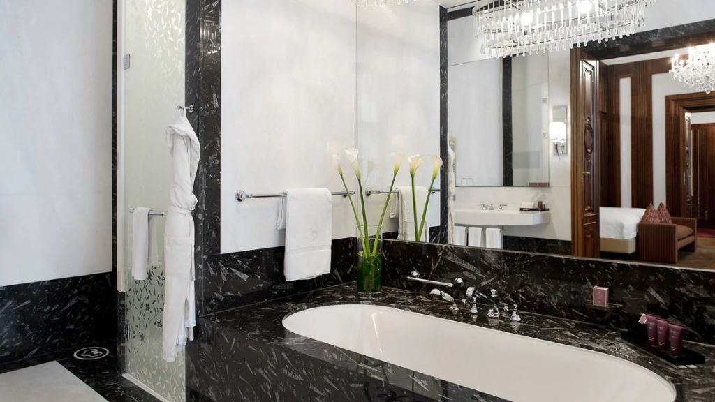 Elegantes Badezimmer mit schwarzem Marmor und spiegelndem Dekor