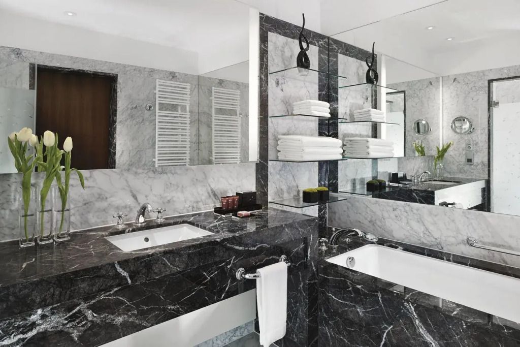 Luxuriöses Badezimmer mit Marmor-Dekor und großzügigem Spiegel im Hotelzimmer
