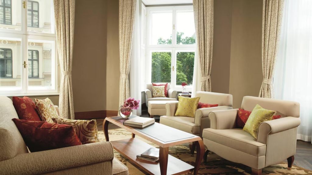 Heller Wohnbereich der Suite mit großen Fenstern und eleganten Sitzgelegenheiten