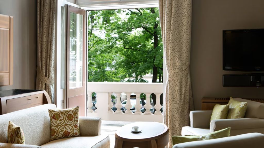 Gemütliche Sitzecke mit Blick auf den grünen Balkon in der Suite