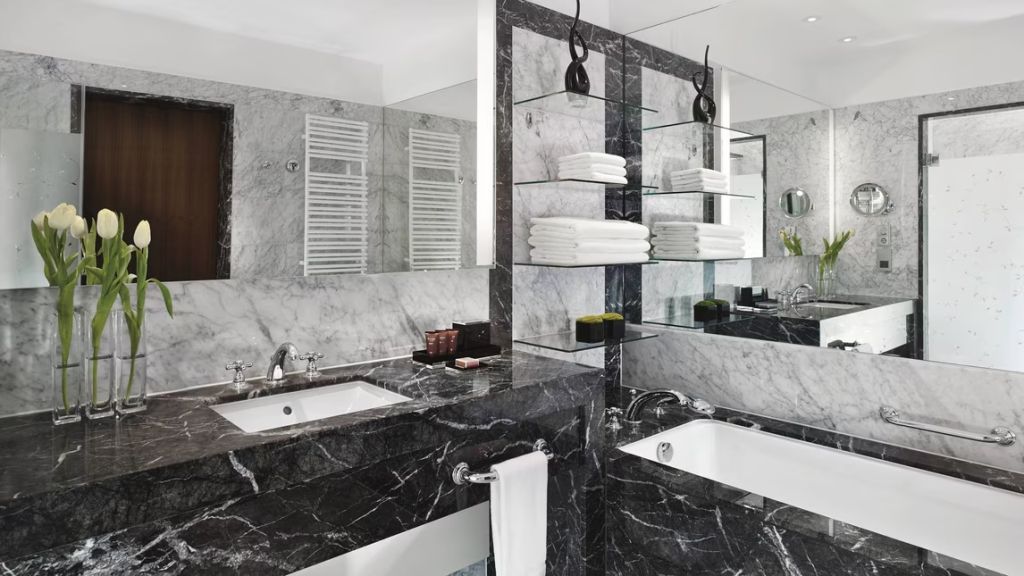 Luxuriöses Badezimmer mit schwarzem Marmor und modernen Armaturen