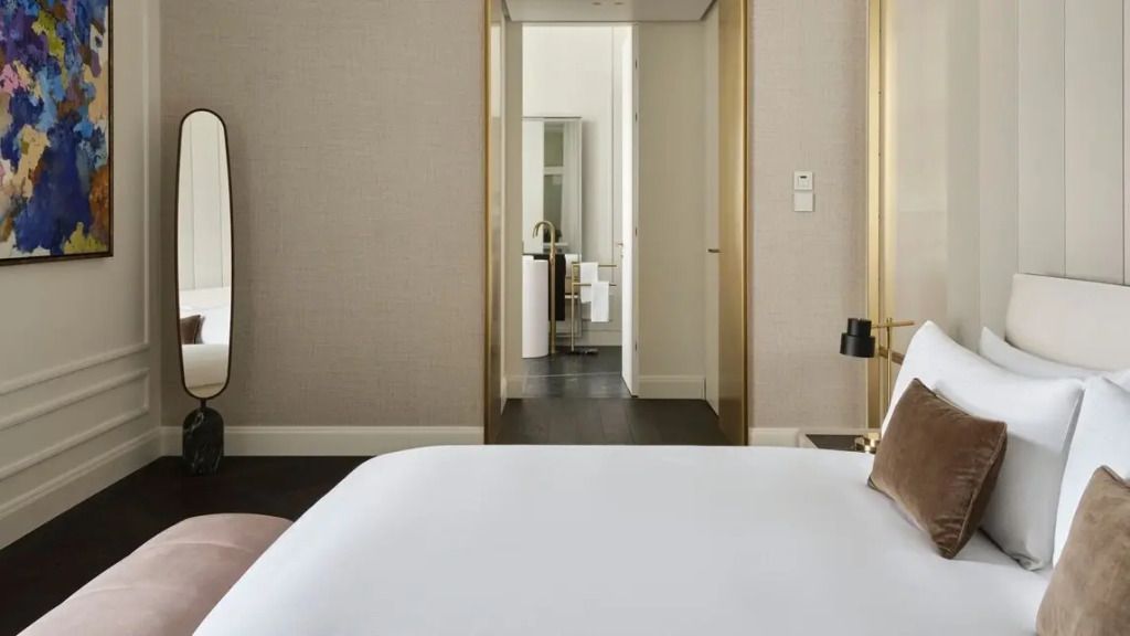 Durchgang vom Schlafzimmer zum stilvollen Badezimmer mit goldenen Akzenten