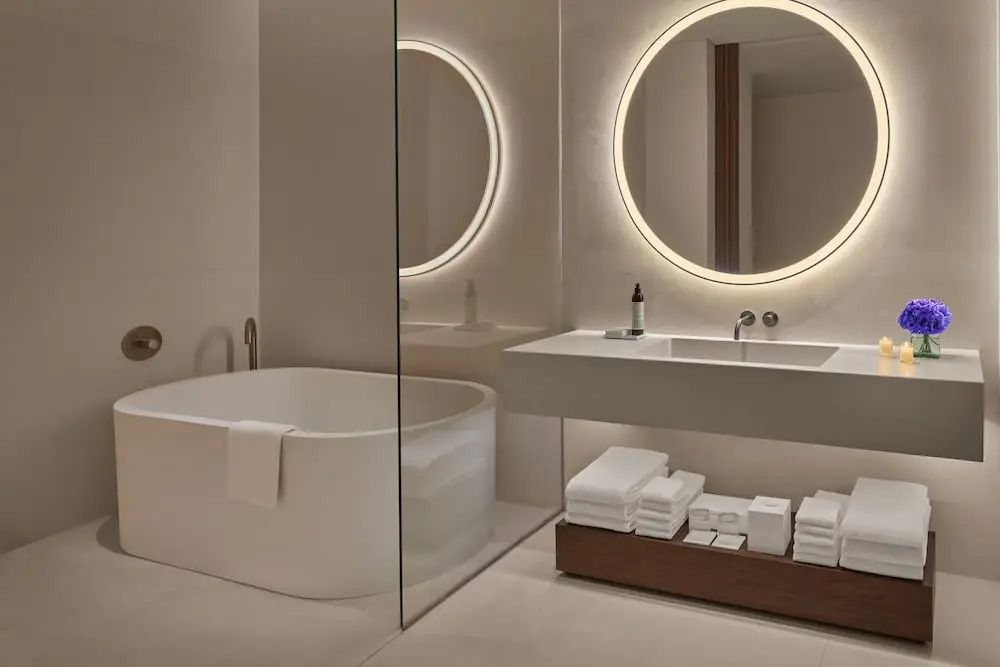 Luxuriöses Badezimmer mit freistehender Badewanne und eleganter Beleuchtung im Deluxe Zimmer