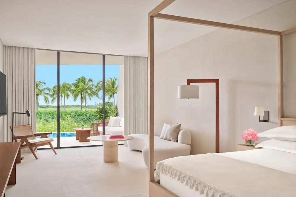 Elegantes Hotelzimmer mit großer Fensterfront, modernem Design und Meerblick.
