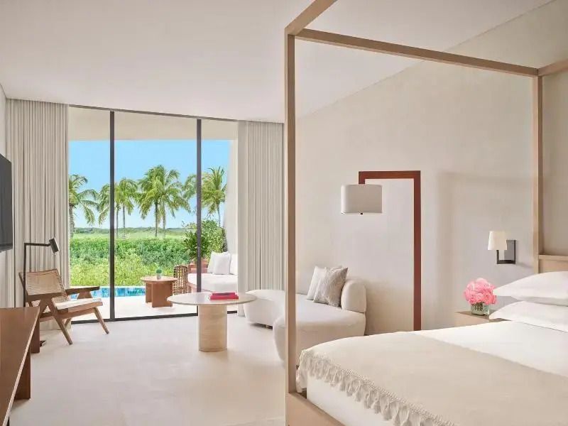 Geräumiges Schlafzimmer mit Doppelbett und direktem Poolblick.