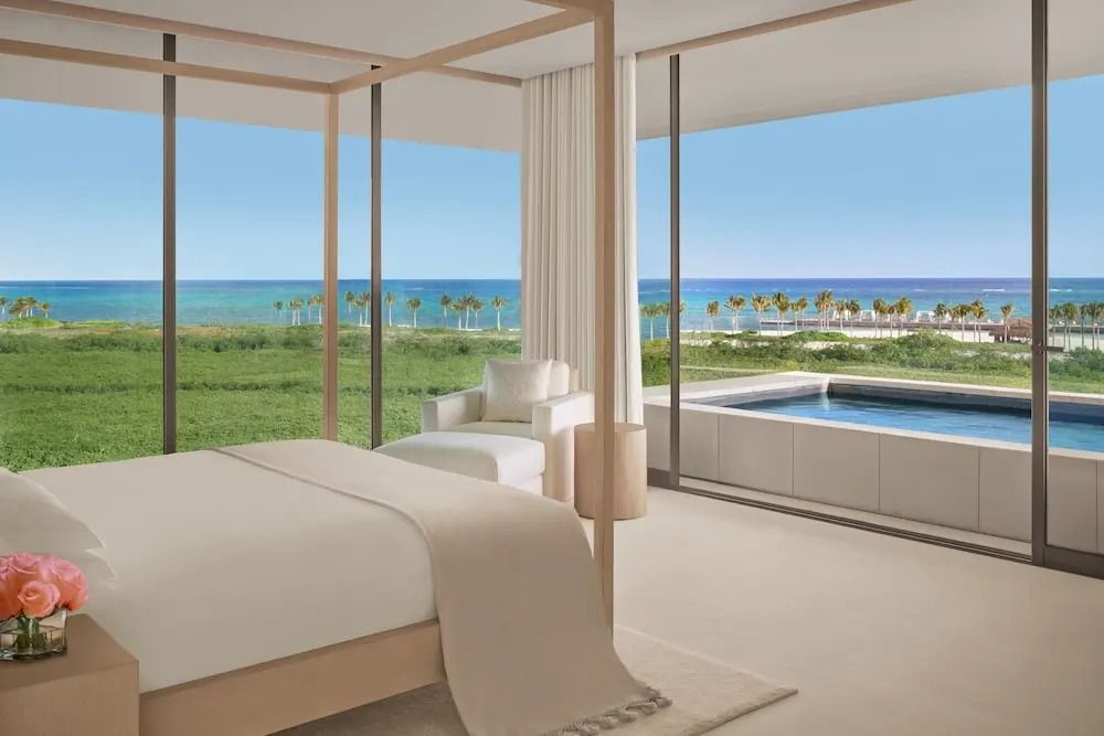 Schlafzimmer mit Himmelbett, direktem Meerblick und privatem Pool