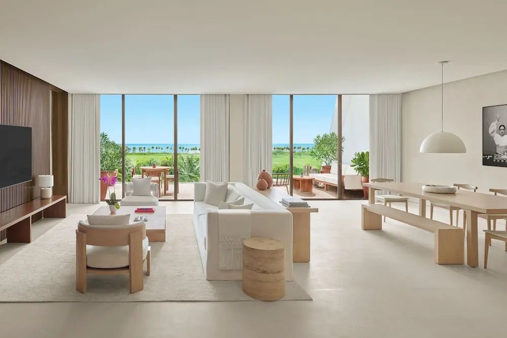 Weitläufiger Wohnbereich mit großen Fenstern und Blick ins Grüne und aufs Meer