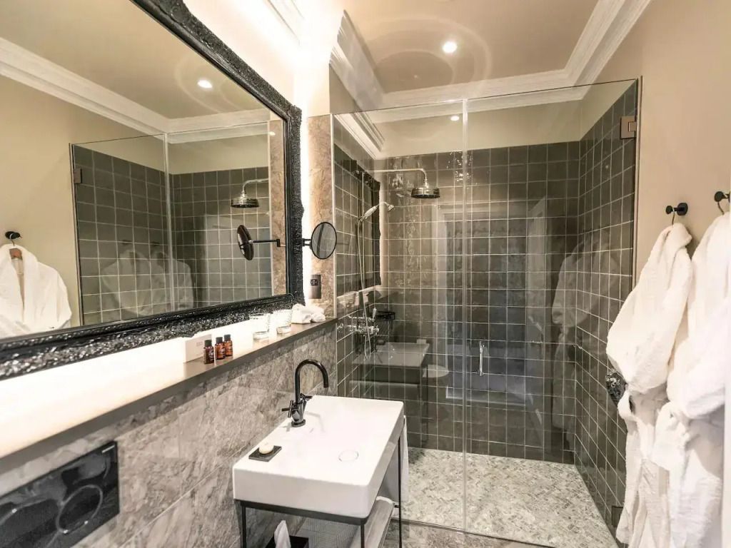 Modernes Badezimmer mit großer Dusche und Marmorwaschtisch.