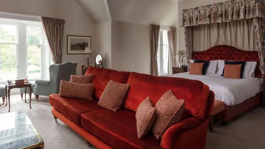Elegantes Zimmer mit rotem Sofa und luxuriösen Vorhängen im Schloss Roxburghe.