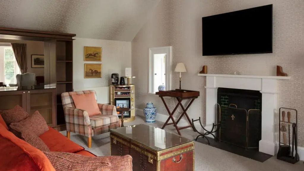 Wohnbereich der Castle Suite mit Kamin, TV und stilvoller Einrichtung.