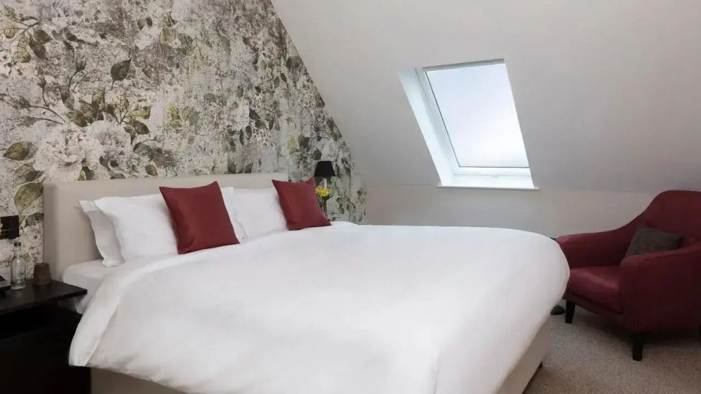 Modernes Schlafzimmer mit Dachfenster und großen Kissen
