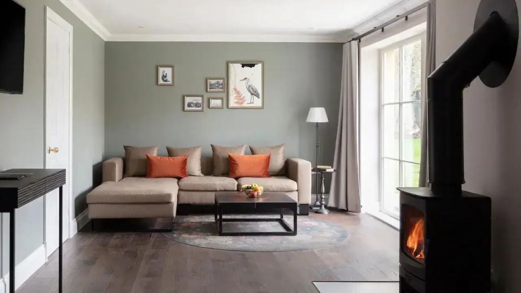 Gemütliches Wohnzimmer mit kunstvoller Wanddekoration und großen Fenstern