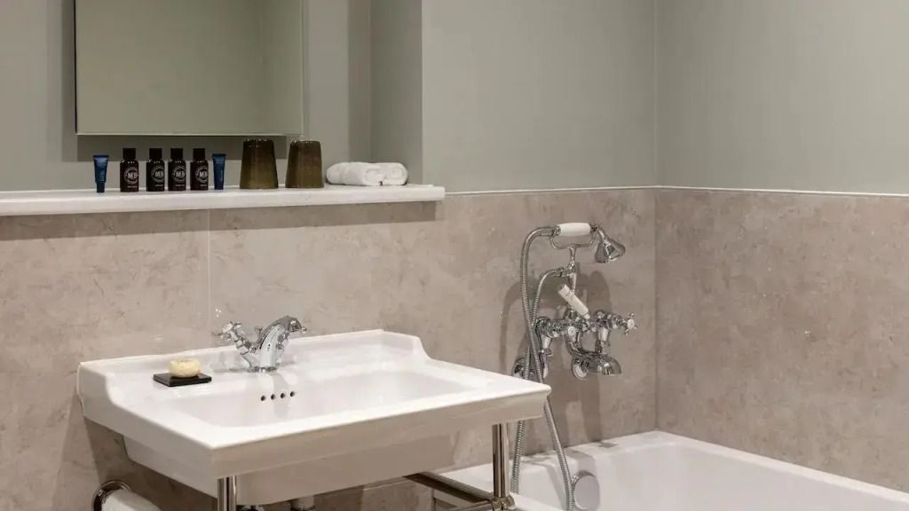 Luxuriöses Badezimmer mit eleganter Armatur und weiße Sanitäranlagen