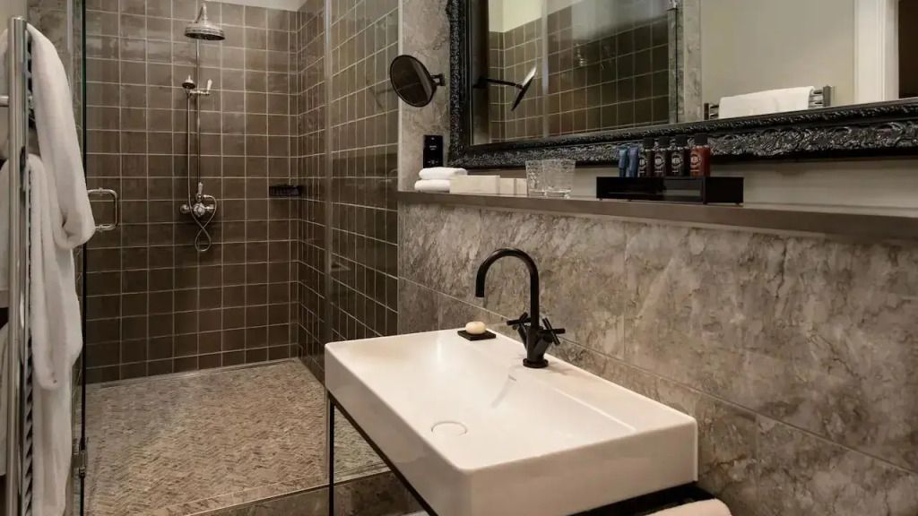 Modernes Badezimmer mit großem Waschbecken und begehbarer Dusche.