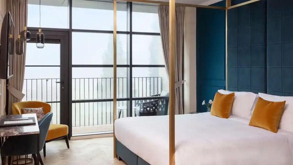 Geräumige Suite mit Himmelbett und großem Fenster mit Balkon