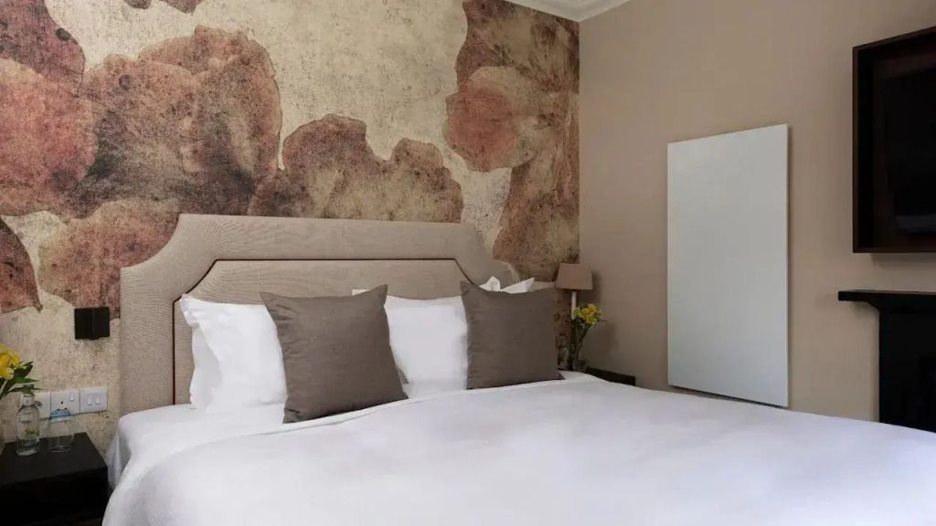 Schlafzimmer mit dezenter Wandgestaltung und eleganten Kissen.