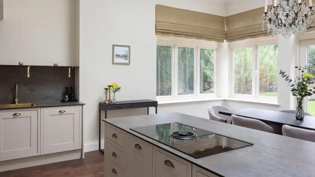 Moderne Küche mit eleganten Schränken und großen Fenstern.