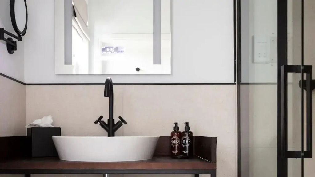 Badezimmer mit elegantem Waschbecken und hochwertigen Pflegeprodukten.