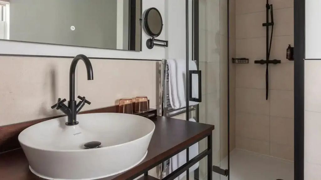 Zeitloses Badezimmer mit eleganter Waschschale und geräumiger Dusche.